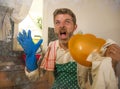 Dramatic grunge portrait of  house husband or single man in kitchen apron doing domestic chores washing dishes or cooking in Royalty Free Stock Photo