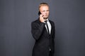 Portrait of serious confident business man talking on the cellphone over dark gray background with vignette. Royalty Free Stock Photo