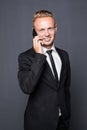 Portrait of serious confident business man talking on the cellphone over dark gray background with vignette. Royalty Free Stock Photo