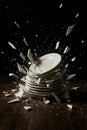 Dramatic high-speed shot of a stack of white plates shattering into pieces Royalty Free Stock Photo