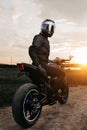 Dramatic image of biker sitting on motorcycle in sunset on the country road. Royalty Free Stock Photo
