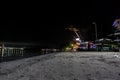 Dramatic angle image of beach at night in the caribbean with lighted restaurants and bars and a loading dock in the background. Royalty Free Stock Photo