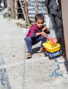 Dramatic image of dominican boy playing with his toy truck. Royalty Free Stock Photo