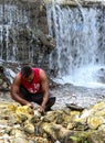 Dramatic image of dominican cleaning fish at waterfalls of san rafael park, dominican republic.