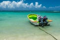 Dramatic image of a green fishing boat anchored on the caribbean coast with aqua blue water. Royalty Free Stock Photo