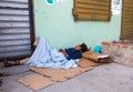 Dramatic image of homeless women sleeping in the sidewalk of a small caribbean town.