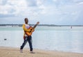 Dramatic image of a man playing the guitar the caribbean coast to tourist. Royalty Free Stock Photo