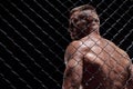 Dramatic image of a mixed martial arts fighter standing in an octagon cage. The concept of sports, boxing, martial arts Royalty Free Stock Photo