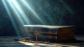 Dramatic image showing a bright light beam shining on an old bible with a rosary laying in front of it Royalty Free Stock Photo