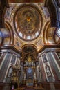 A dramatic interior view of a baroque church featuring a richly decorated dome with a painted ceiling, ornate columns Royalty Free Stock Photo