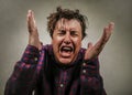 Dramatic isolated portrait of young desperate and stressed man suffering anxiety crisis and depression problem screaming Royalty Free Stock Photo