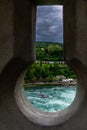 Dramatic Keyhole view of Rhein Rhine water fall in switzerland, background has green forest and dramatic cloudy sky Royalty Free Stock Photo