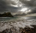 Dramatic landscape - dark stormy sky and sunlight, sea waves, co