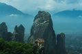 Dramatic landscape of Meteora monastery in morning fog. Royalty Free Stock Photo
