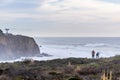 Dramatic landscape of the Pacific Ocean coast, Pillar Point, Half Moon Bay, California; huge waves and surfers visible in the