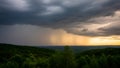 Dark storm clouds over green forest with distant rain and sunset light Royalty Free Stock Photo