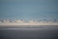 Dramatic landscape with snow mountain under blue cloudy sky. Pastel colors, snow-capped mountains over a mountain lake, they look Royalty Free Stock Photo