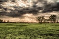 Dramatic landscape view with sun rays shining through a dark cloudy sky Royalty Free Stock Photo