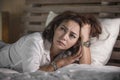 Dramatic lifestyle portrait of attractive sad and depressed middle aged around 50s woman feeling upset alone on bed suffering Royalty Free Stock Photo