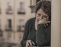 Dramatic lifestyle portrait of mature woman on her 70s crying depressed and sad at home balcony feeling desperate suffering Royalty Free Stock Photo