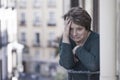 Dramatic lifestyle portrait of mature woman on her 70s crying depressed and sad at home balcony feeling desperate suffering Royalty Free Stock Photo