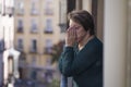 Dramatic lifestyle portrait of mature woman on her 70s crying depressed and sad at home balcony feeling desperate suffering Royalty Free Stock Photo