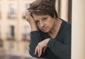 Dramatic lifestyle portrait of mature woman on her 70s crying depressed and sad at home balcony feeling desperate suffering Royalty Free Stock Photo