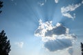 Dramatic light in the late afternoon blue sky with puffy clouds and bright sunbeams Royalty Free Stock Photo