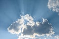 Dramatic light in the late afternoon blue sky with puffy clouds and bright sunbeams Royalty Free Stock Photo