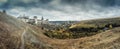 Storm clouds gather around Medieval gothic castle on the hill. Panoramic view Royalty Free Stock Photo