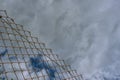 Dramatic lined cloudscape with separation by metallic net. Conceptual, abstract