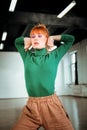 Red-haired professional choreographer in a green turtleneck feeling creative