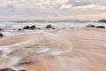 Wavy sea with rocks near a beach Royalty Free Stock Photo
