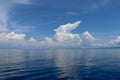 Dramatic looking clouds over sea. Billowing clouds hang over the ocean. Beautiful summer blue sky and white clouds over calm sea. Royalty Free Stock Photo