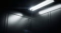 Dark Elevator Interior with Bright Fluorescent Light Fixture and Metallic Walls Royalty Free Stock Photo