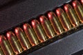 A dramatic macro photograph of a row of .45 caliber pistol ammunition lined up neatly in a textured black case Royalty Free Stock Photo