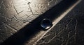 Dramatic macro shot of a single water droplet resting on a rough, dark surface with linear texture, highlighting themes of Royalty Free Stock Photo