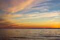 Dramatic clouds on the blue sky in pink yellow red shades in the sunset light on Lake Baikal, beautiful scenic seascape Royalty Free Stock Photo