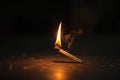 A dramatic moment a matchstick lights up a brown wooden surface