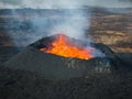 Dramatic moment of a volcano eruption, a crater with boiling magma, aerial view