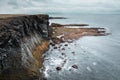 Dramatic mossy cliffs in front of blue ocean in Arnarstapi, Iceland on cloudy day Royalty Free Stock Photo