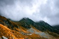 Dramatic Mountain Landscape Rugged Slopes, Golden Grass, and Low Clouds Royalty Free Stock Photo