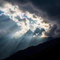 Dramatic mountainous landscape with dark clouds partially obscuring rugged peaks Royalty Free Stock Photo