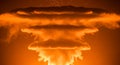 Dramatic mushroom cloud explosion rising in glowing orange sky Royalty Free Stock Photo