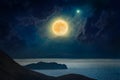 Dramatic mystical background - rising full moon in dark night sky above mountains with reflection in water. Full moon occurs Royalty Free Stock Photo