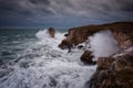 Dramatic nature background - big waves and dark rock in stormy sea, stormy weather. Dramatic scene. Royalty Free Stock Photo