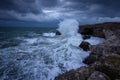 Dramatic nature background - big waves and dark rock in stormy sea, stormy weather. Dramatic scene. Contrasting colors. Royalty Free Stock Photo
