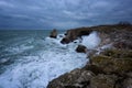 Dramatic nature background - big waves and dark rock in stormy sea, stormy weather. Dramatic scene. Royalty Free Stock Photo