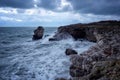 Dramatic nature background - big waves and dark rock in stormy sea, stormy weather. Dramatic scene. Royalty Free Stock Photo