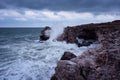 Dramatic nature background - big waves and dark rock in stormy sea, stormy weather. Dramatic scene. Royalty Free Stock Photo